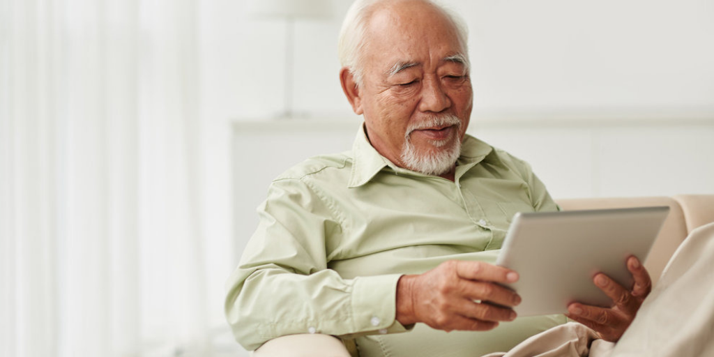 Man using tablet whilst sitting on couch.