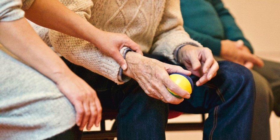 Close up of elderly man's hands holding a small ball