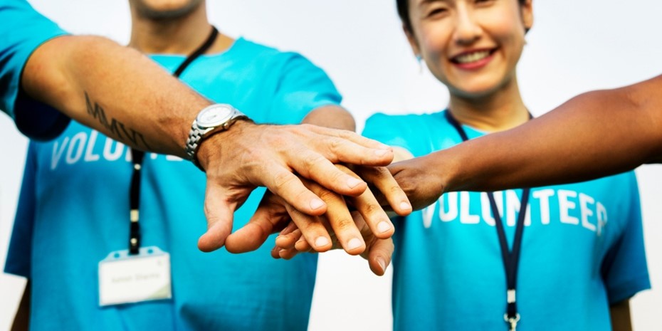 Volunteers putting hands on top of one another
