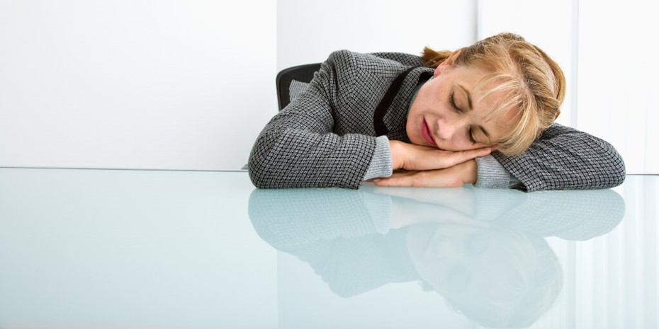 Woman in corporate attire sleeping on desk
