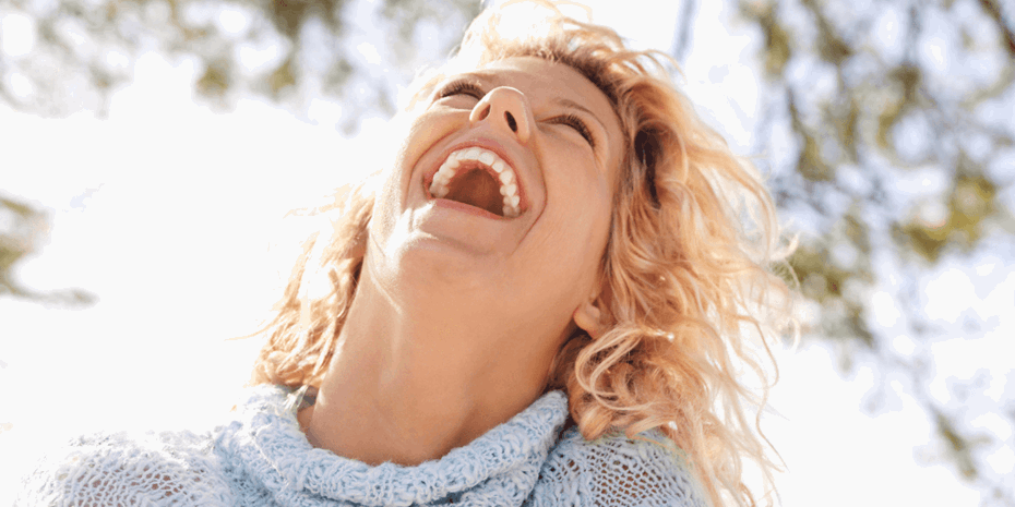 Woman with blonde hair laughing outside