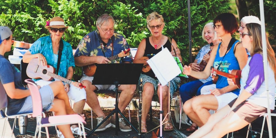 Group of people playing ukeles and singing