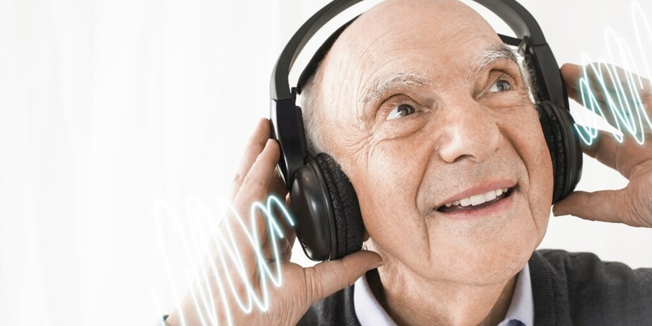Elderly man smiling and listening to music with headphones on