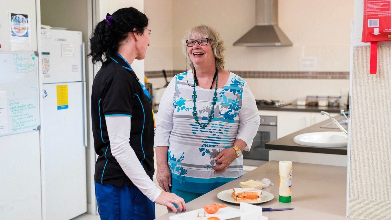 Brightwater Oats Street_disability staff and client preparing a tomato sandwich for lunch with mayonaisse in the clean tidy kitchen