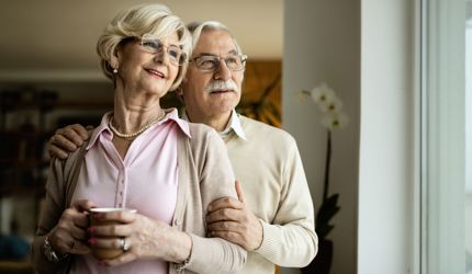 Smiling Senior Couple Looking Through Window