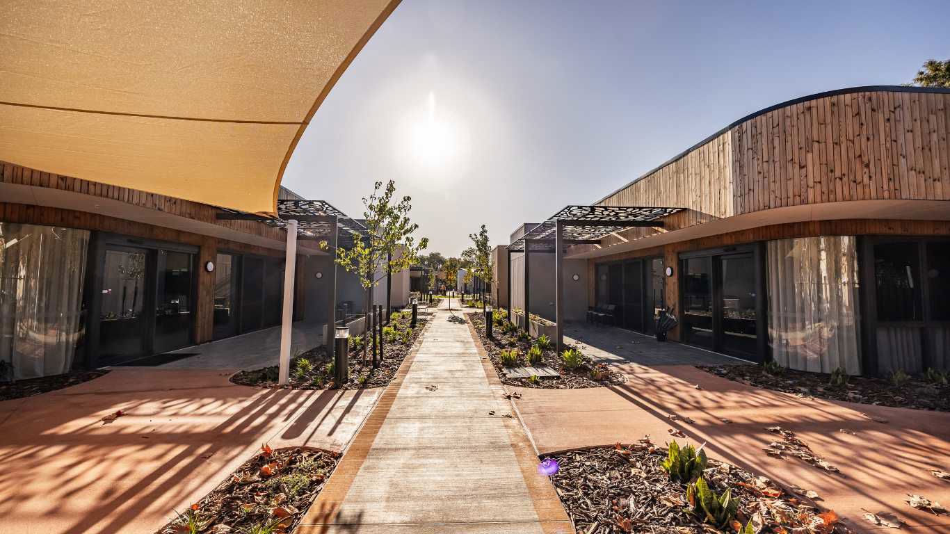 Brightwater Piara Waters_Huntington's Disease campus outdoor area with connecting paths, building with wooden panelling and trees