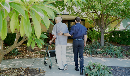 A resident at Madeley with Parkinsons disease is assisted by physiotherapist