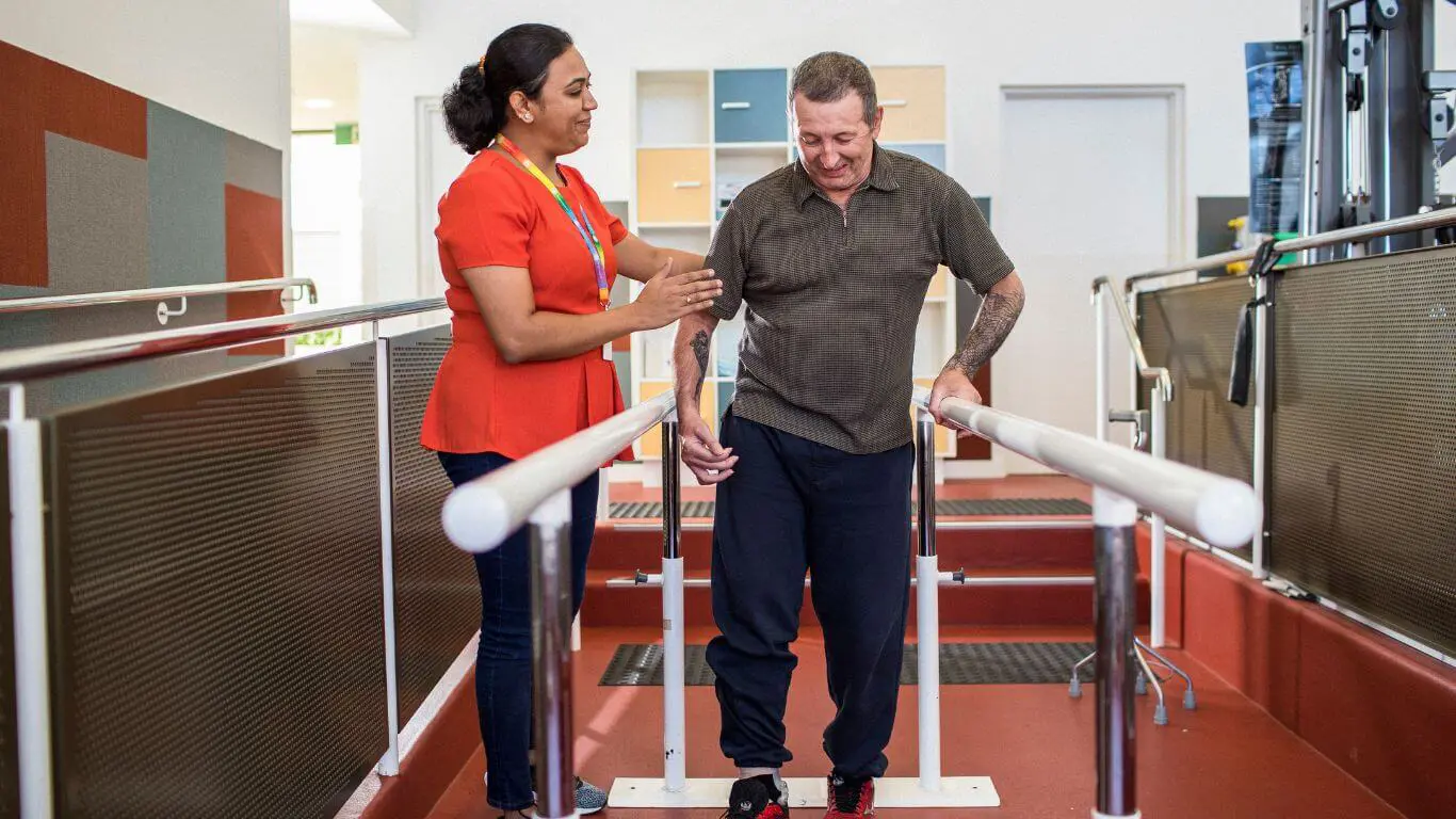 Brightwater Physiotherapy Services_physiotherapist helping disability client learn to walk again