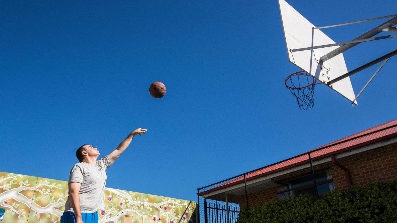 Brightwater Oats Street Transitional Rehabilitation Program_disability client shooting a basketball into hoop on basketball court