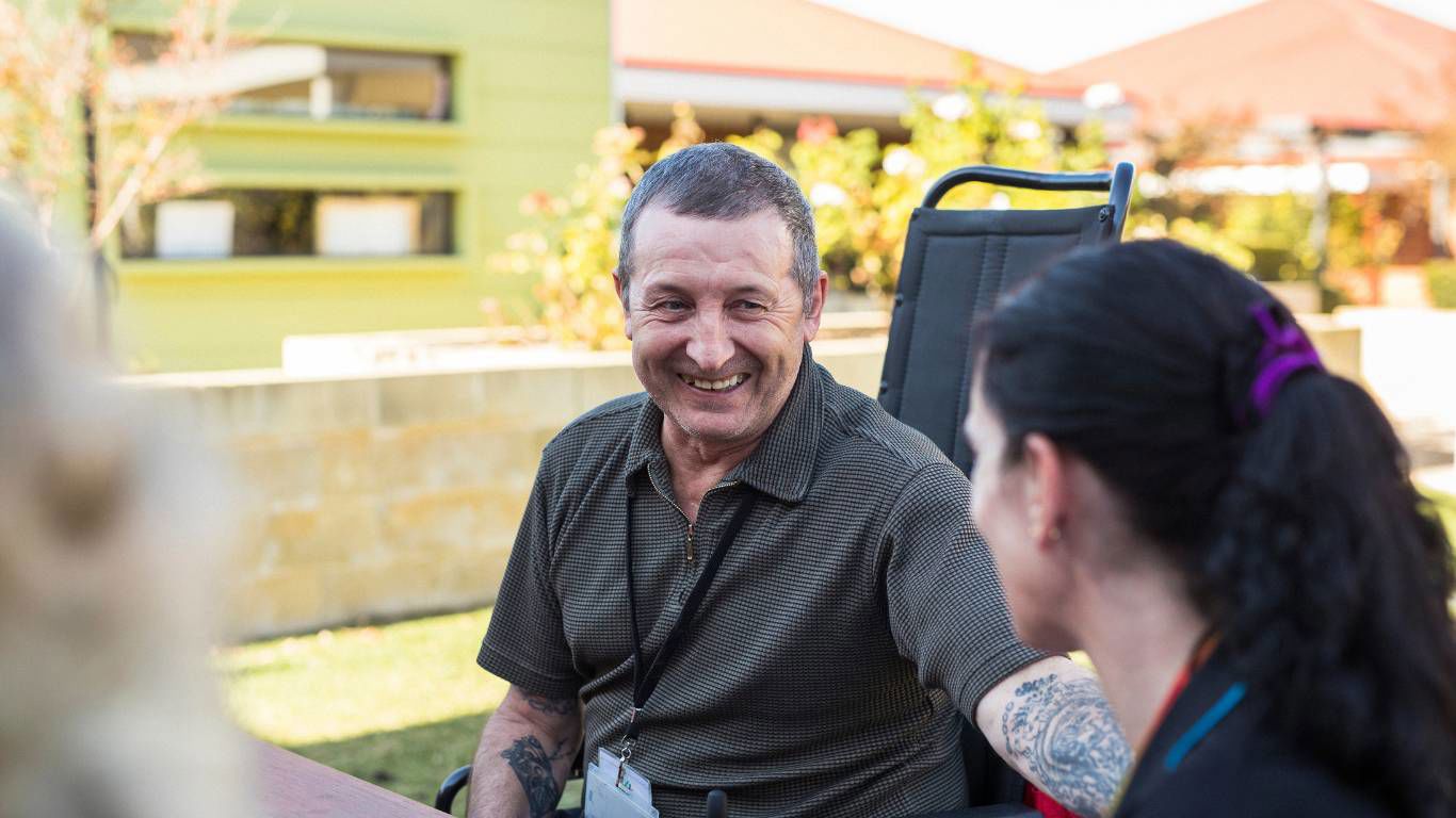 Brightwater Oats Street_disability client laughing with staff member in the garden